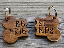 Load image into Gallery viewer, Matching halves wooden “Best Friends” dog tags engraved with pet names, split design on two collars with silver keyrings.  
