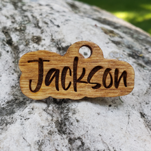 Load image into Gallery viewer, Custom wooden dog tag engraved with the dog’s name in bold shadow-outlined lettering, lightweight design, attached to a collar with a silver keyring
